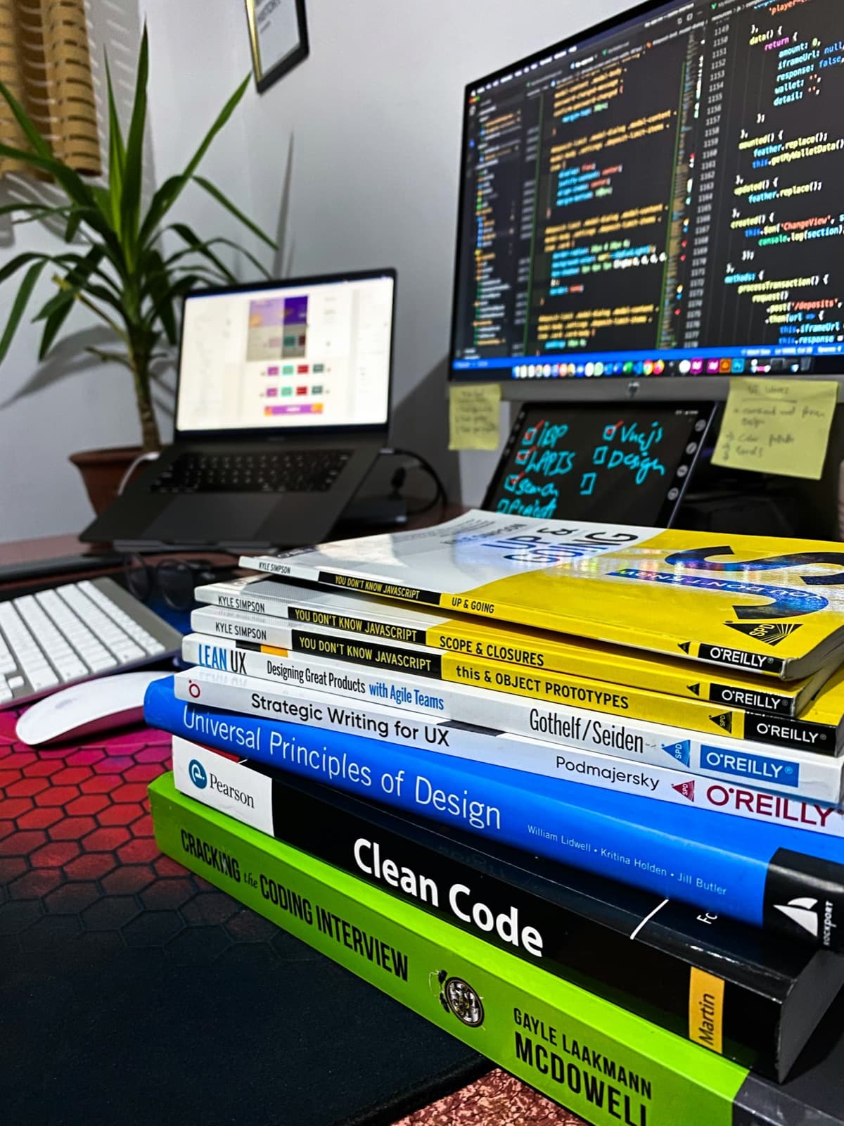 Software craft books in front of a multi-screen workstation