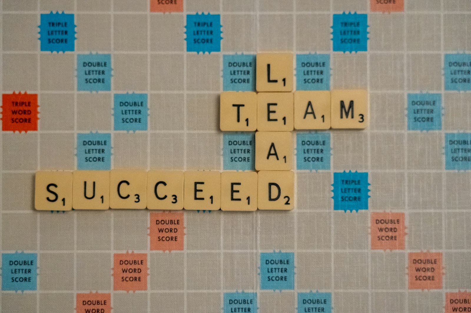 Scrabble tiles spelling team, lead, and succeed