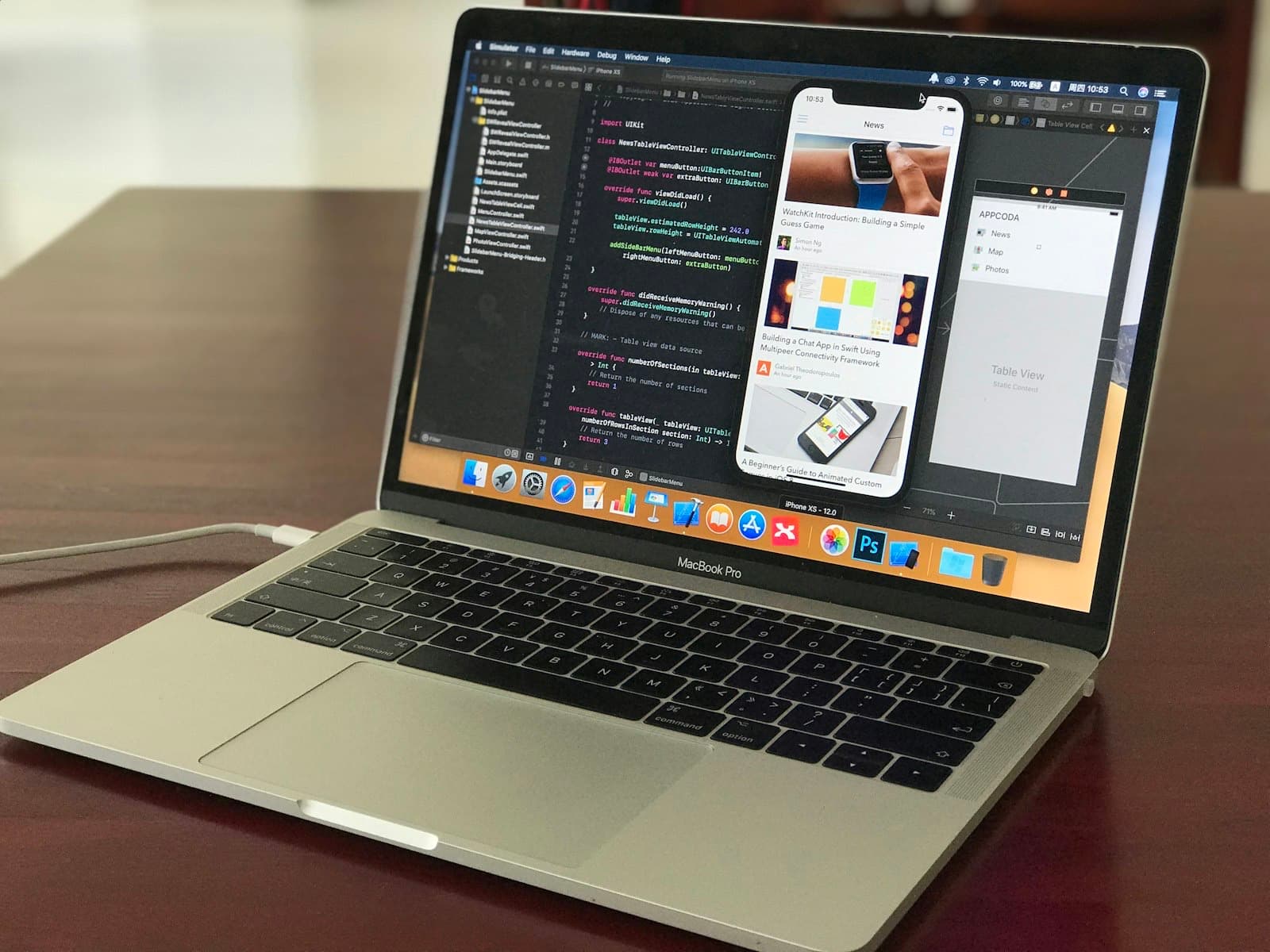Laptop showing a code editor next to an app preview on a phone